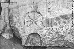 Ancient wall carving of the Goddess Seshat, with her pot-leaf symbol over her head.