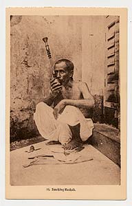 Man smoking through a `nargila` (coconut)